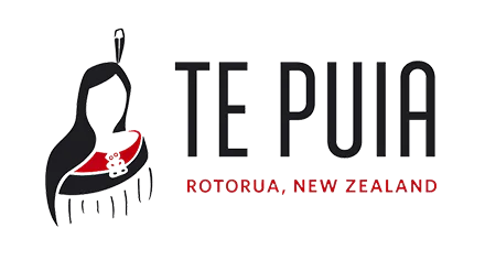 Te Puia logo featuring a stylized Māori woman’s silhouette wearing traditional attire in black and red, alongside the text ‘TE PUIA’ in bold black letters and ‘ROTORUA, NEW ZEALAND’ in smaller red capital letters.