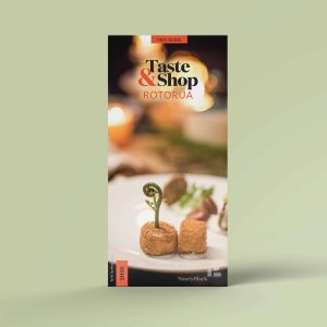 Cover of the Taste & Shop Rotorua guide showing a fine-dining plate with crispy bites and a pikopiko fern.